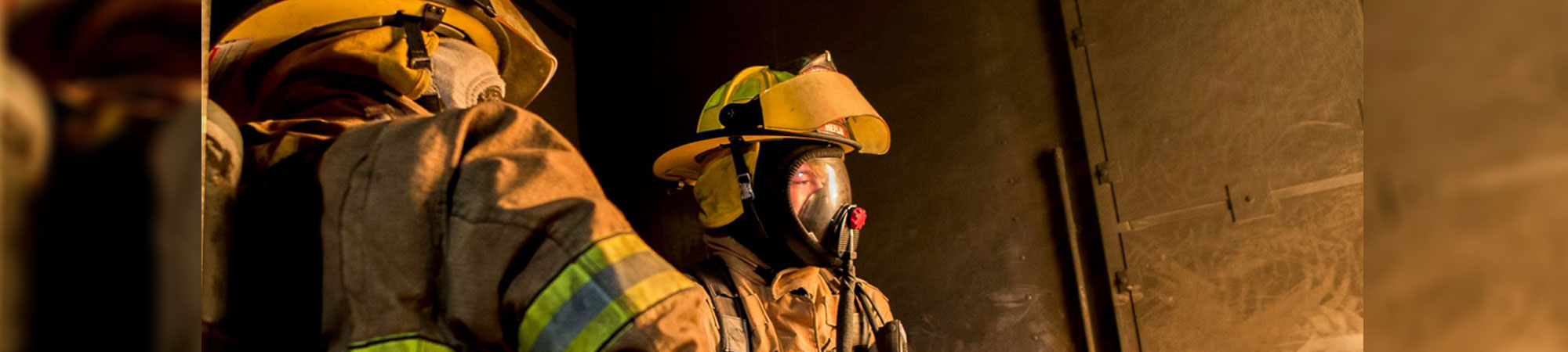 firefighters fighting a fire with a water hose